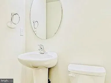 a bathroom with a toilet sink and mirror