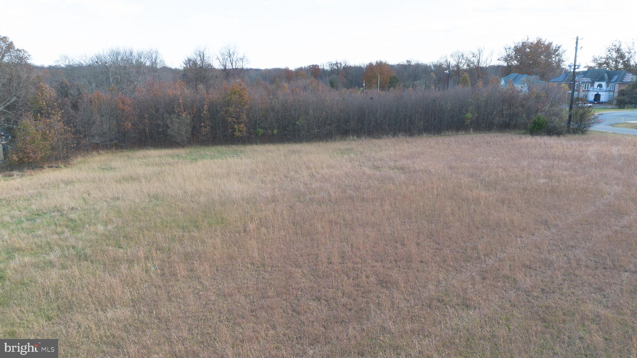 17403 Old Baltimore Road Olney, MD 20832 - Photo 5 of 5 a view of a dry yard with trees in the background