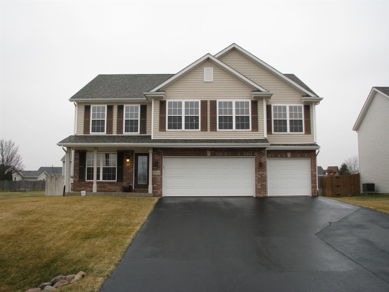 11044 Chicory Ridge Way Roscoe, IL 61073 - Photo 1 of 20 a front view of a house with a yard and garage