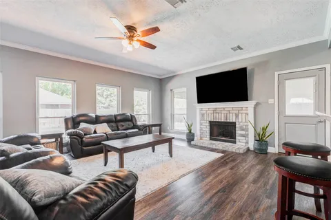 a spacious bedroom with a bed and a flat tv screen on dresser
