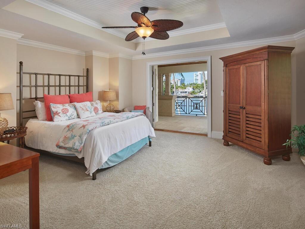 377 Pirates Bight Naples, FL 34103 - Photo 32 of 44 a bedroom with a bed and a chandelier