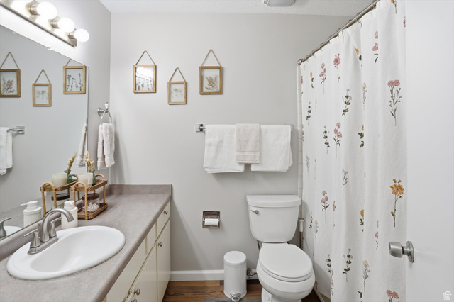 8938 Manchester Lane Sandy, UT 84093 - Photo 33 of 50 Bathroom featuring a single vanity with a laminate countertop, undermount sink, and brushed nickel faucet