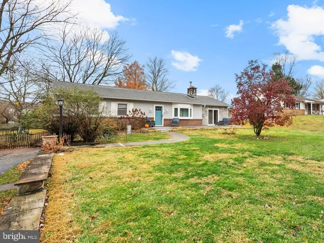 a view of a house with a big yard and large trees