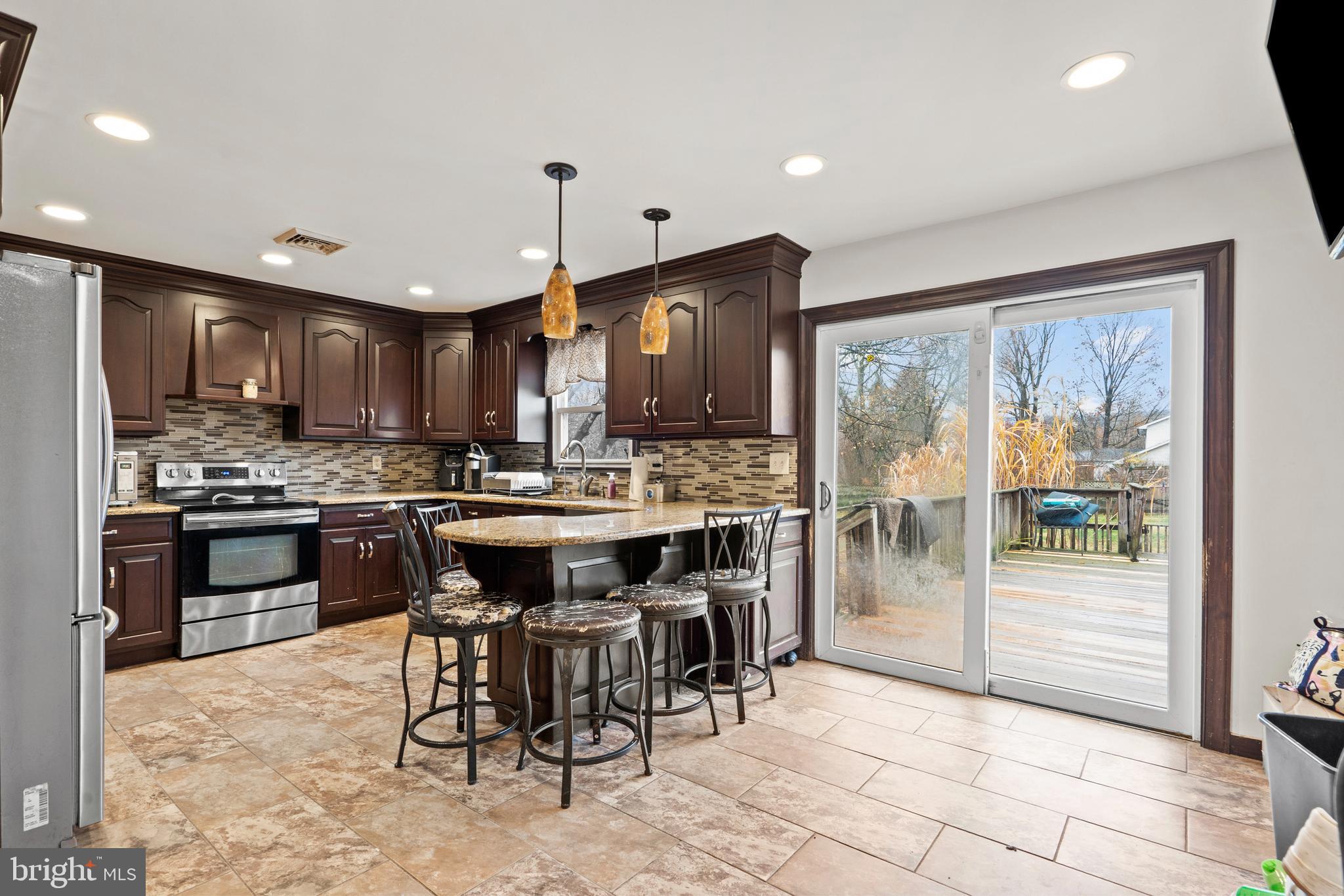 1538 Temple Road Pottstown, PA 19465 - Photo 6 of 29 a kitchen with stainless steel appliances kitchen island granite countertop a refrigerator a stove a sink and a dining table with wooden floor