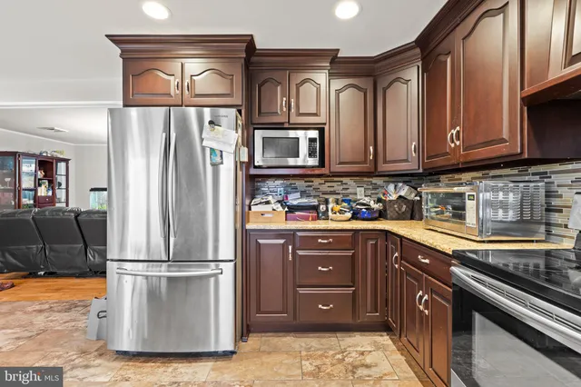a kitchen with stainless steel appliances granite countertop a refrigerator a stove a sink and dishwasher