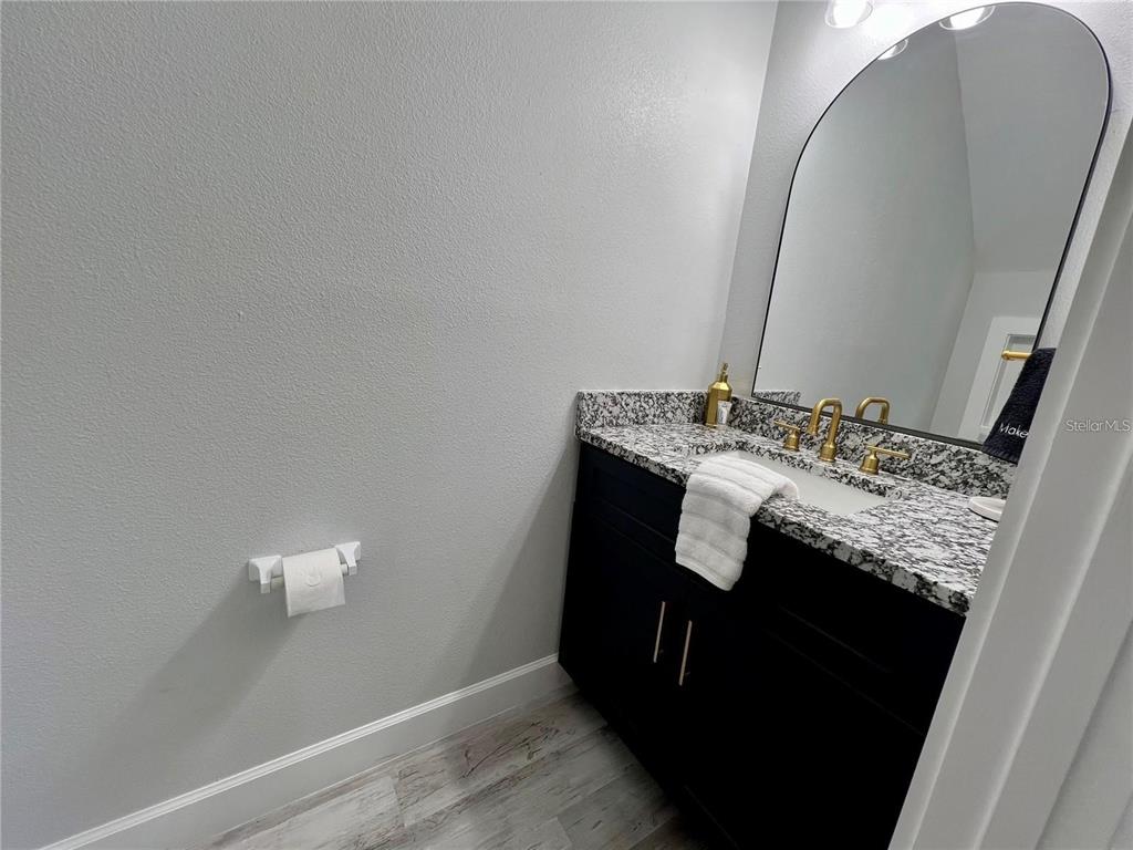 5630 Queener Avenue Port Richey, FL 34668 - Photo 13 of 37 a bathroom with a granite countertop sink and a mirror
