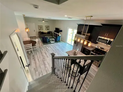 a view of a dining room with furniture wooden floor carpet and a chandelier