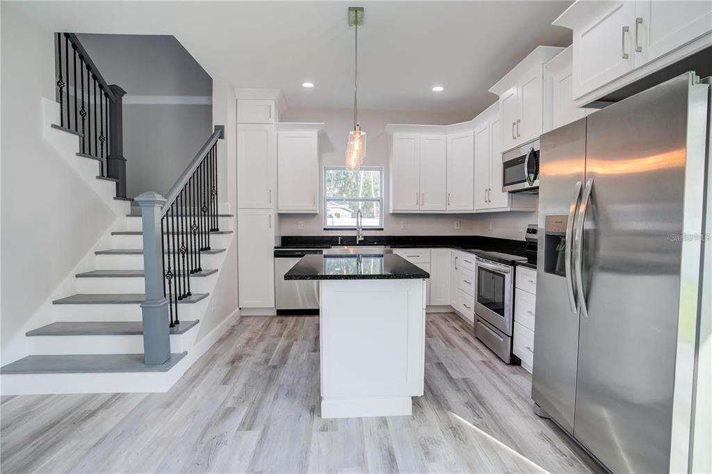5630 Queener Avenue Port Richey, FL 34668 - Photo 16 of 37 a kitchen with white cabinets and stainless steel appliances