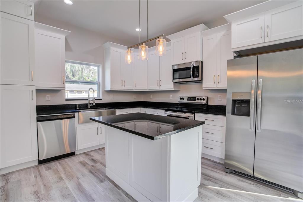5630 Queener Avenue Port Richey, FL 34668 - Photo 17 of 37 a kitchen with a sink stove and refrigerator