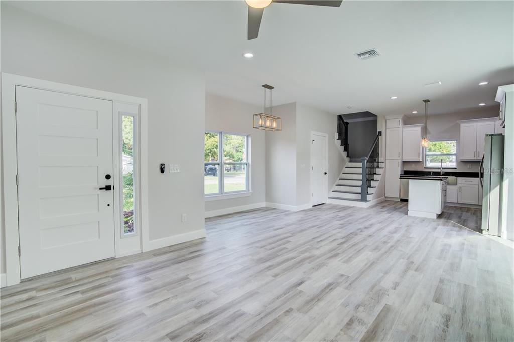 5630 Queener Avenue Port Richey, FL 34668 - Photo 18 of 37 an empty room with wooden floor kitchen view and windows