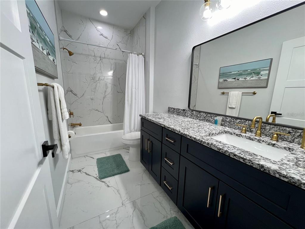 5630 Queener Avenue Port Richey, FL 34668 - Photo 25 of 37 a bathroom with a granite countertop double vanity sink mirror double and shower