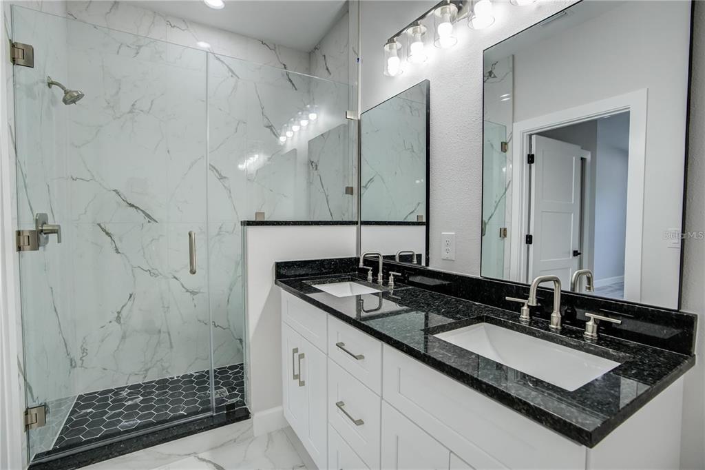 5630 Queener Avenue Port Richey, FL 34668 - Photo 34 of 37 a bathroom with a granite countertop sink a mirror and a shower