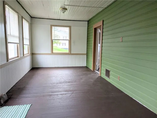 a view of a hallway with wooden floor and a chandelier