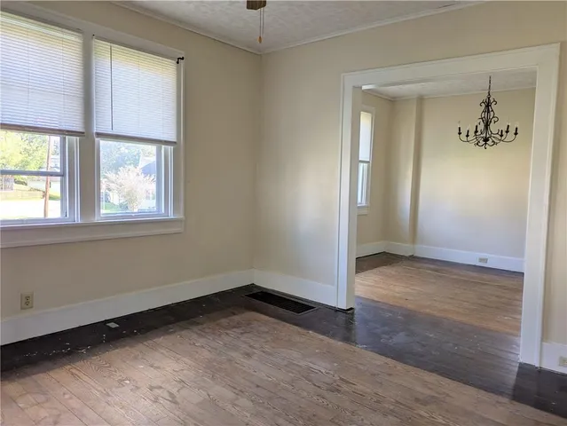a view of a room with wooden floor and chandelier
