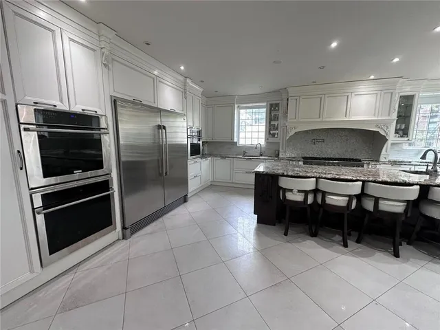 a kitchen with kitchen island a counter top space cabinets and stainless steel appliances