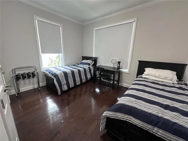 a bedroom with two beds and wooden floor