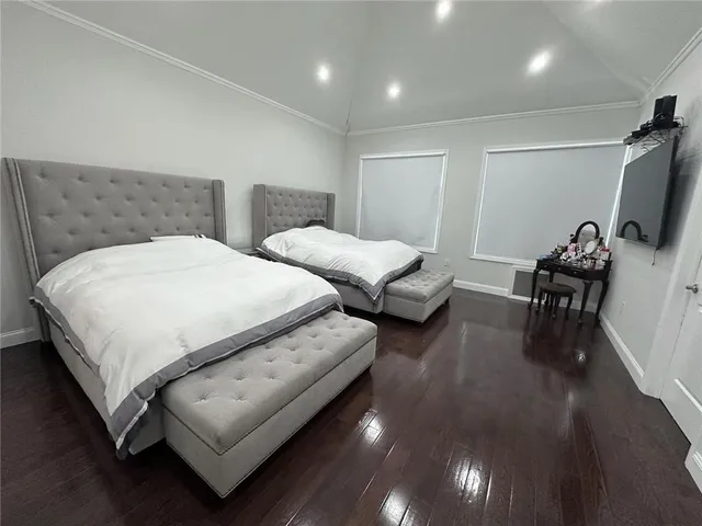 a bedroom with two beds and a flat screen tv