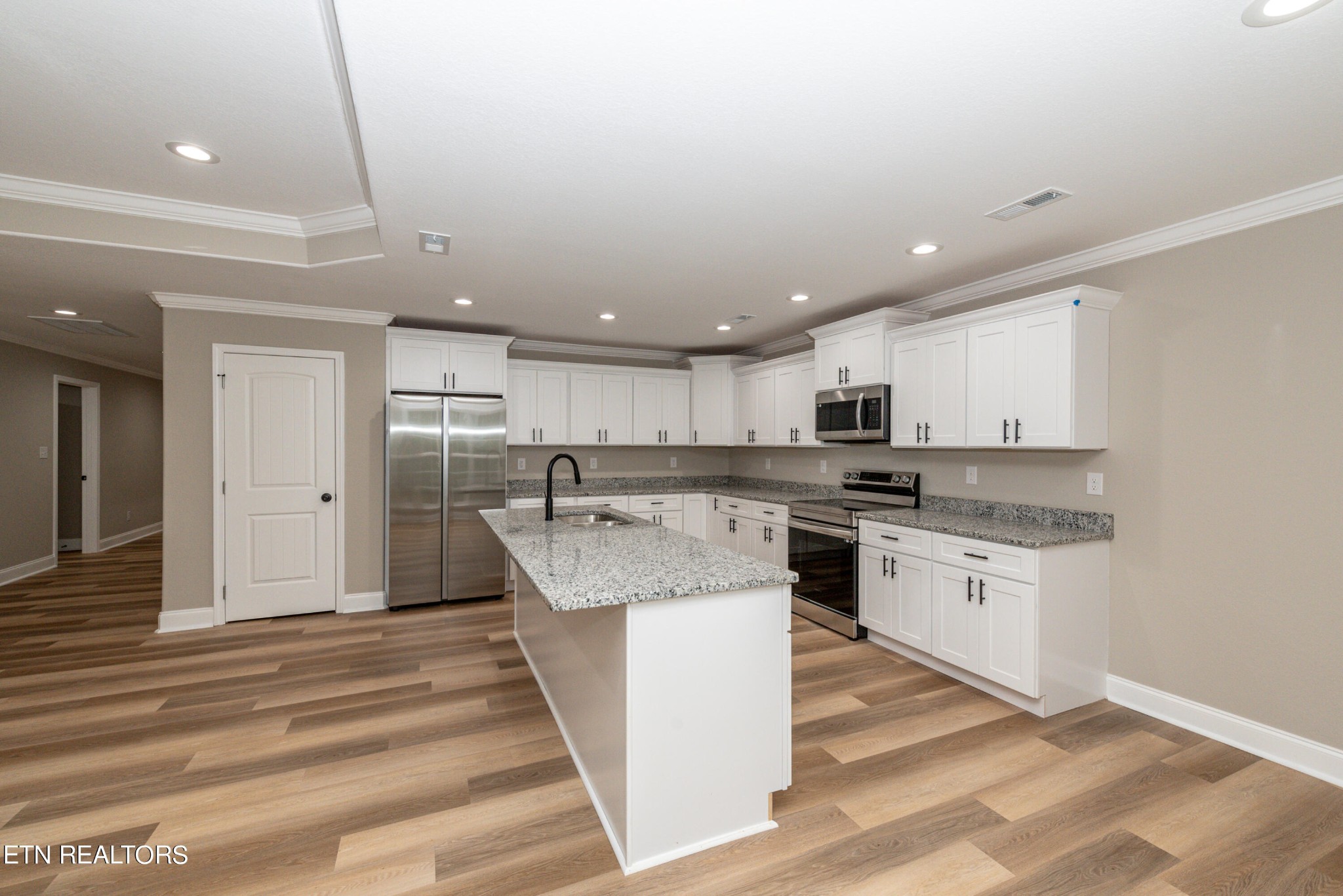 3650 Big Springs Road Friendsville, TN 37737 - Photo 14 of 26 a large kitchen with kitchen island a stove a sink dishwasher and a refrigerator with wooden floor
