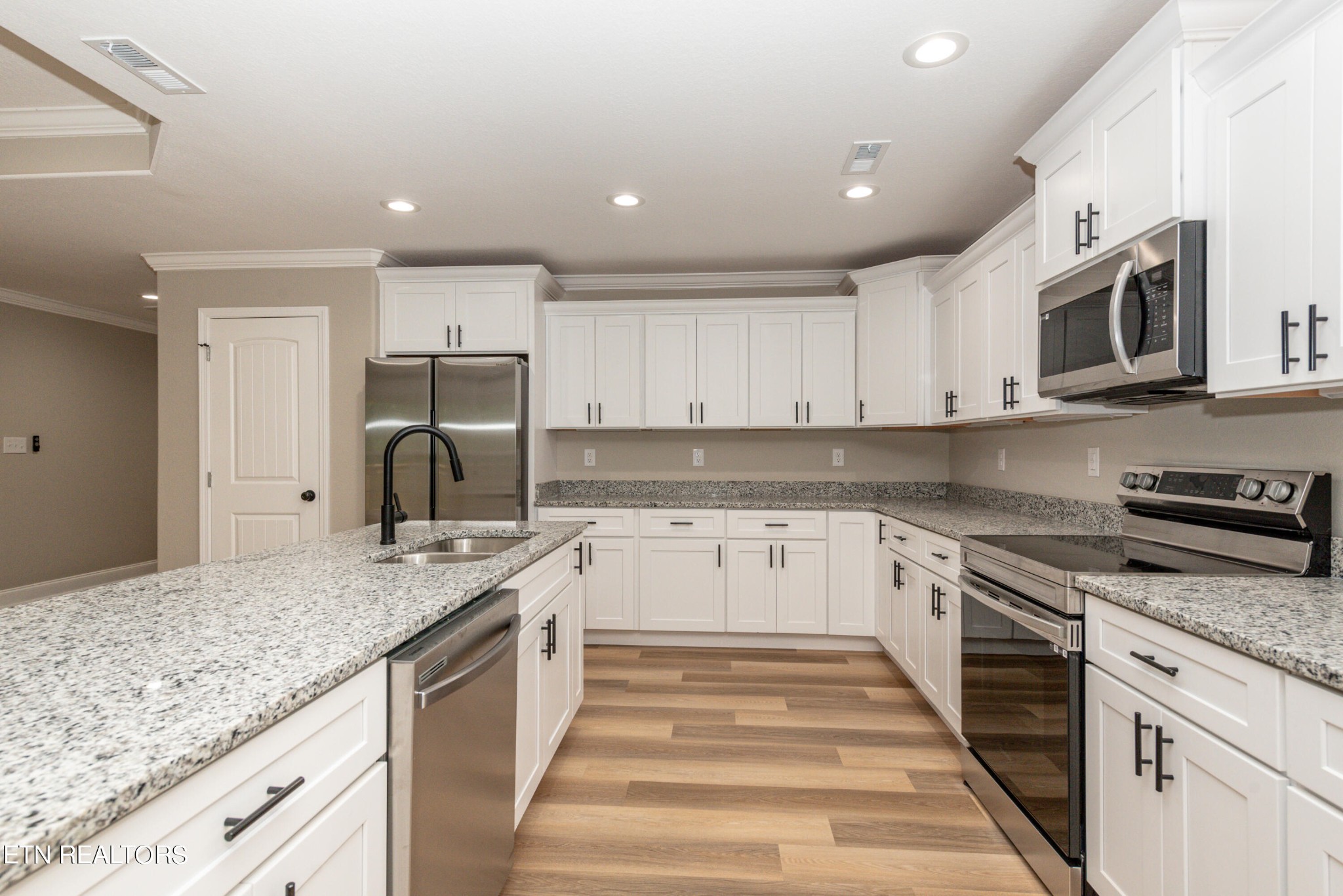 3650 Big Springs Road Friendsville, TN 37737 - Photo 10 of 26 a kitchen with stainless steel appliances granite countertop a sink and dishwasher a stove top oven with white countertops