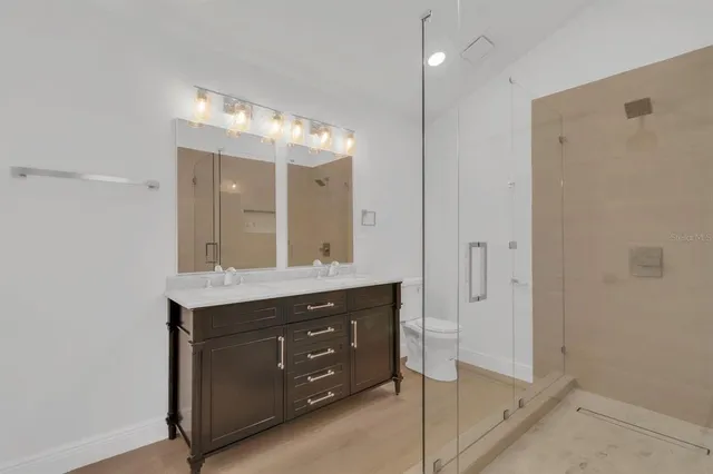 a bathroom with a shower sink and mirror