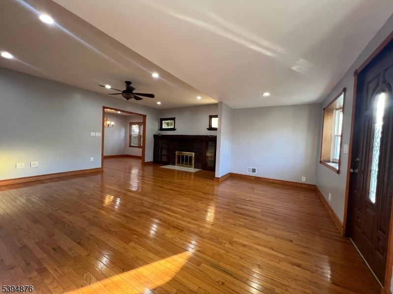 161 Morristown Road Elizabeth, NJ 07208 - Photo 6 of 17 an empty room with wooden floor and fireplace