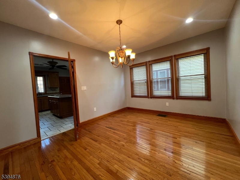161 Morristown Road Elizabeth, NJ 07208 - Photo 7 of 17 a view of empty room with wooden floor and kitchen view
