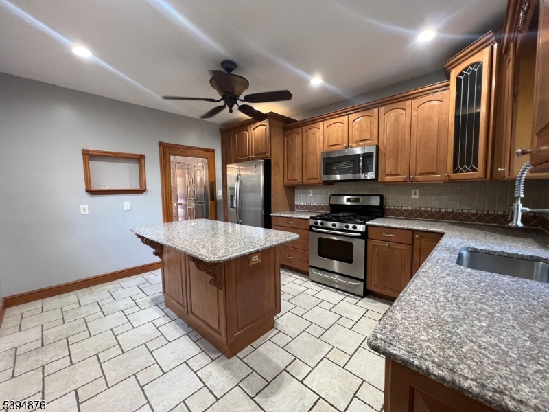 161 Morristown Road Elizabeth, NJ 07208 - Photo 10 of 17 a kitchen with stainless steel appliances granite countertop a stove a sink and a microwave
