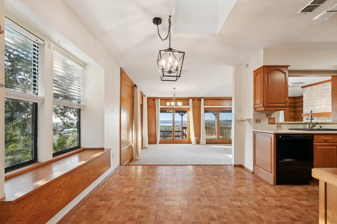 21009 Fawn Ridge Drive Lago Vista, TX 78645 - Photo 11 of 40 Kitchen featuring light countertops, black dishwasher, a chandelier, hanging light fixtures, and brown cabinetry