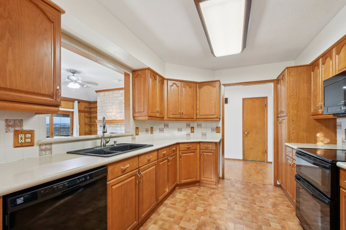 21009 Fawn Ridge Drive Lago Vista, TX 78645 - Photo 13 of 40 Kitchen featuring black appliances, light countertops, brown cabinetry, and ceiling fan