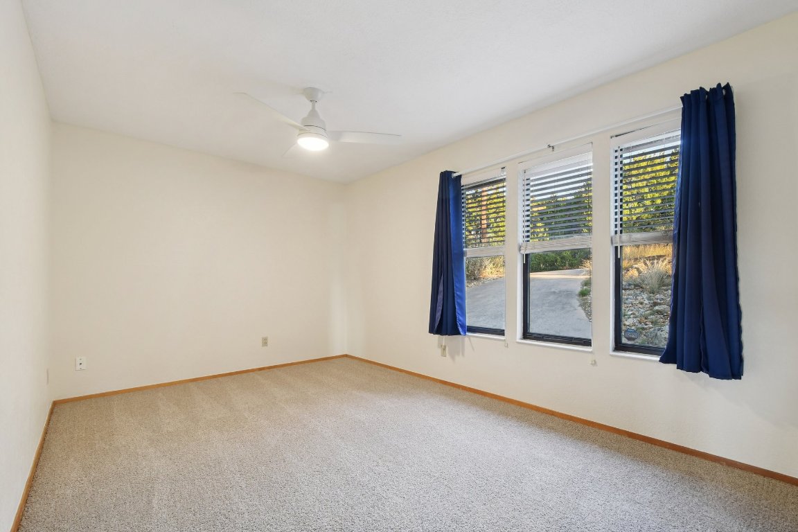 21009 Fawn Ridge Drive Lago Vista, TX 78645 - Photo 22 of 40 Carpeted spare room with baseboards and a ceiling fan