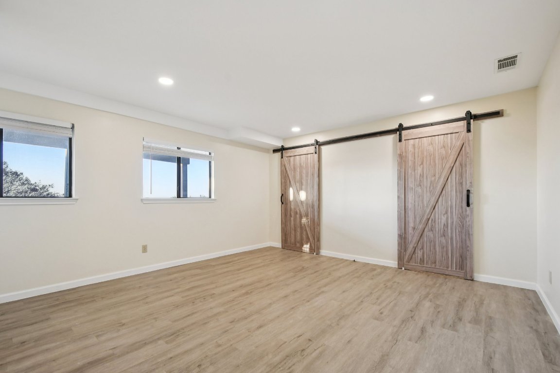 21009 Fawn Ridge Drive Lago Vista, TX 78645 - Photo 32 of 40 a view of an empty room with wooden floor and a ceiling fan