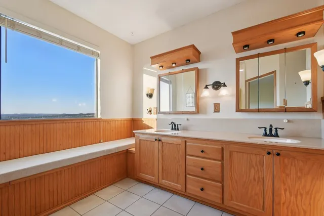 a bathroom with a double vanity sink a mirror and a bathtub