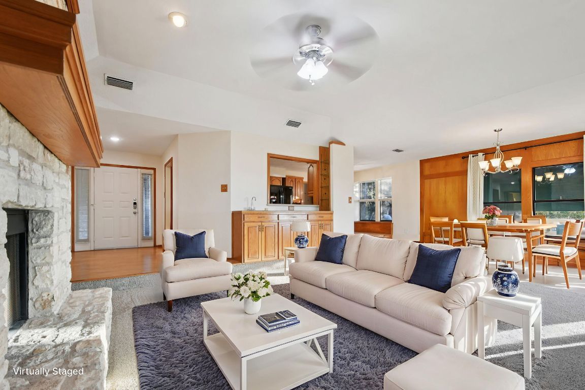 21009 Fawn Ridge Drive Lago Vista, TX 78645 - Photo 8 of 40 Living room featuring a fireplace, a ceiling fan, and a chandelier