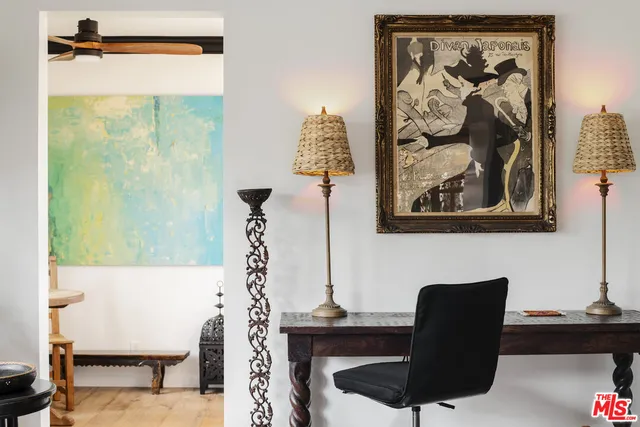 a living room with furniture and a painting on the wall