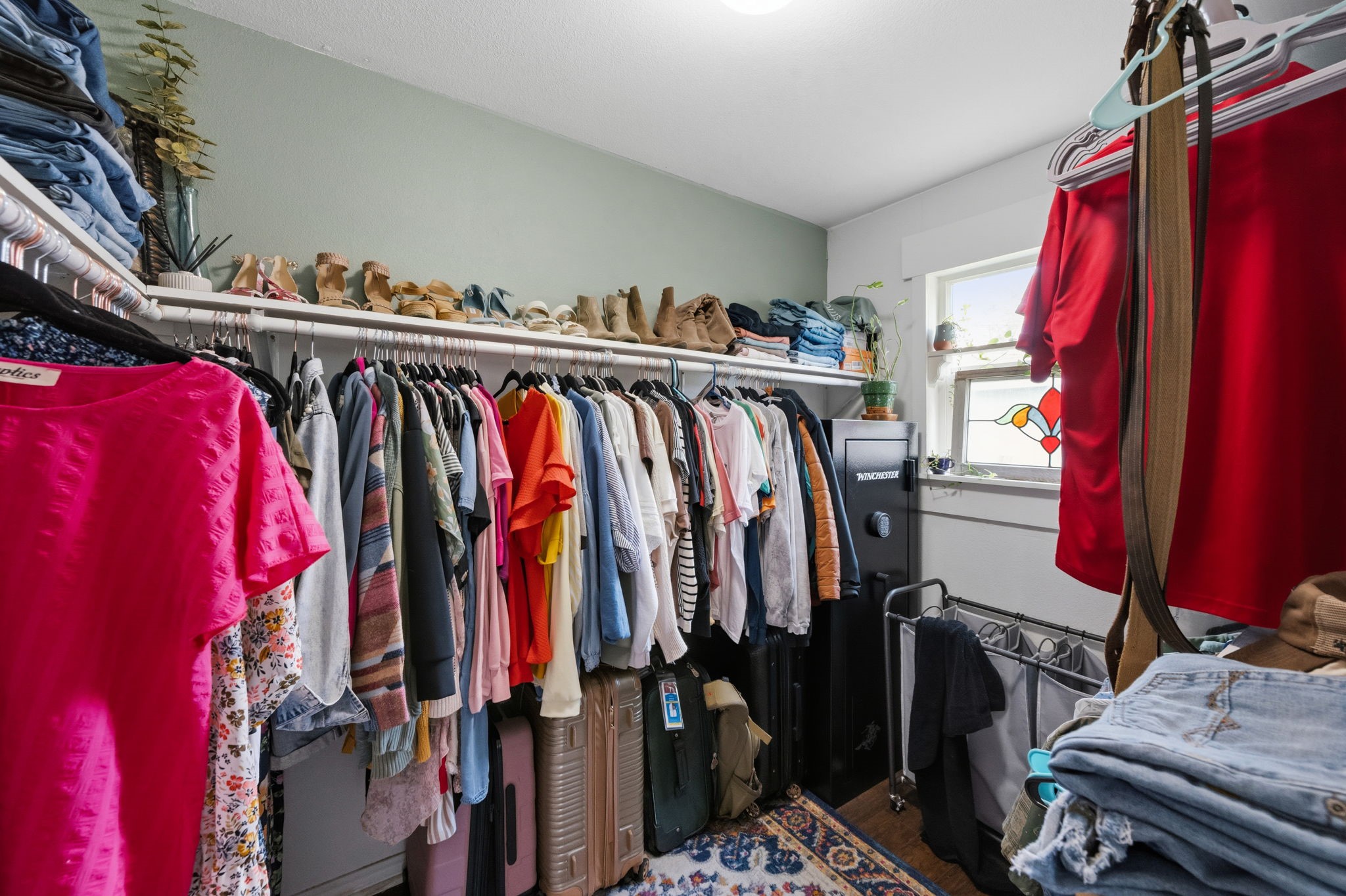431 Corydon Drive Houston, TX 77336 - Photo 19 of 26 Spacious walk-in closet tucked behind a rustic sliding barn door, offering ample room for organization. A window invites in natural light.