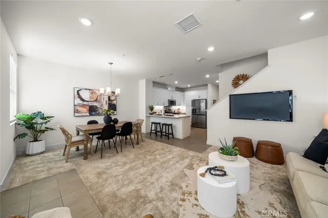 a living room with furniture a flat screen tv and kitchen view