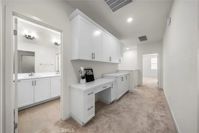 a large white kitchen with a lot of counter space and a sink