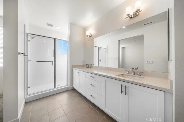 a spacious bathroom with a granite countertop sink a mirror and a shower