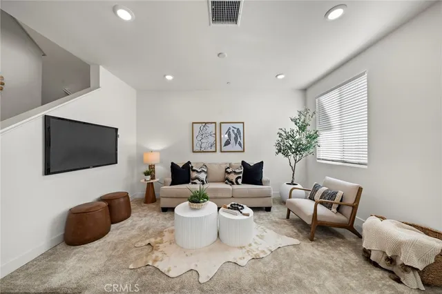 a living room with furniture a flat screen tv and a large window