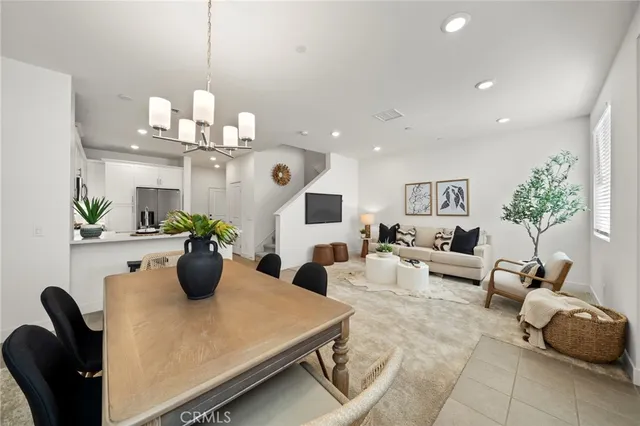 a living room with furniture potted plant and kitchen view