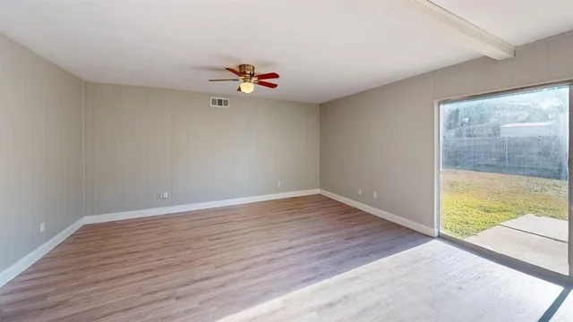 wooden floor in an empty room with a window