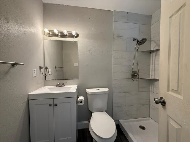 a bathroom with a toilet a sink a shower and mirror