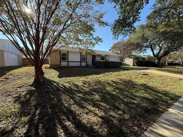 a view of a yard covered with snow in front of house