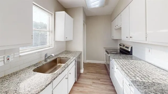 a kitchen with a sink stove top oven and cabinets