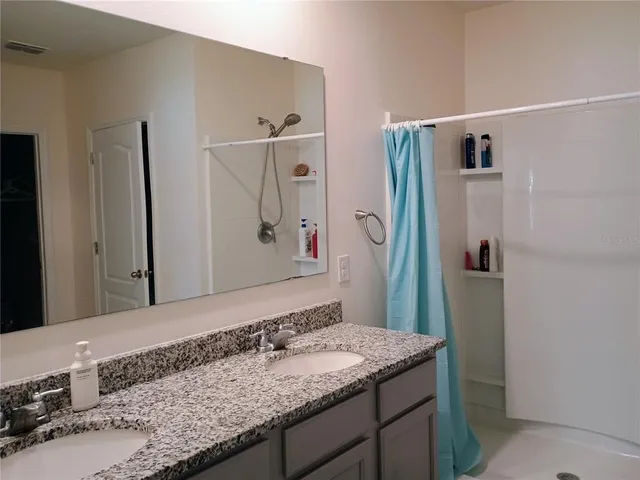 a bathroom with a granite countertop sink and a mirror