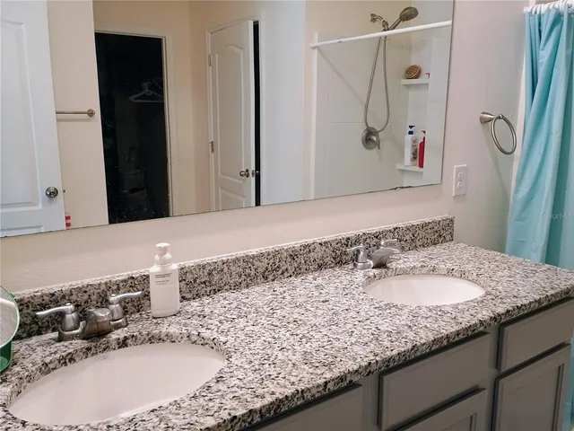 a bathroom with a granite countertop sink and a mirror