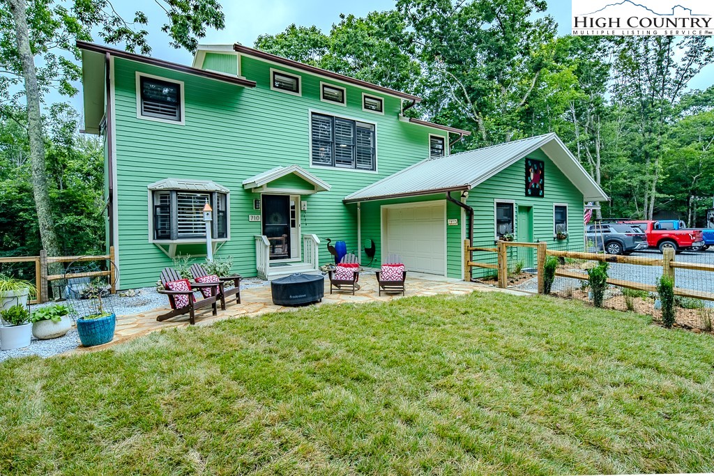 a view of a house with a yard and sitting area
