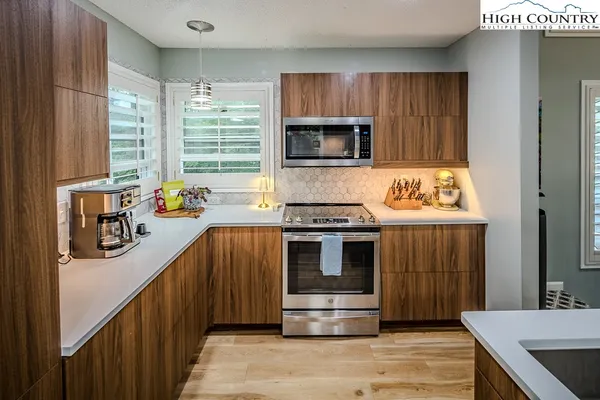 a kitchen with stainless steel appliances a stove a sink and a microwave