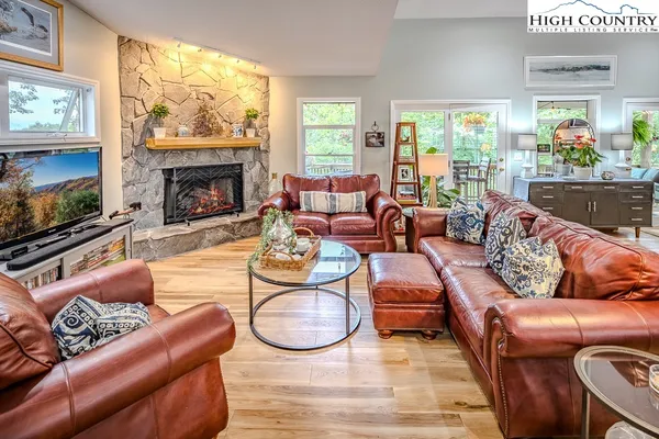 a living room with furniture a fireplace a large window and a flat screen tv