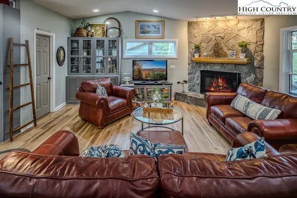 a living room with furniture a fireplace and a flat screen tv